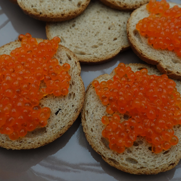 Crostini guarniti con uova di trota arancioni